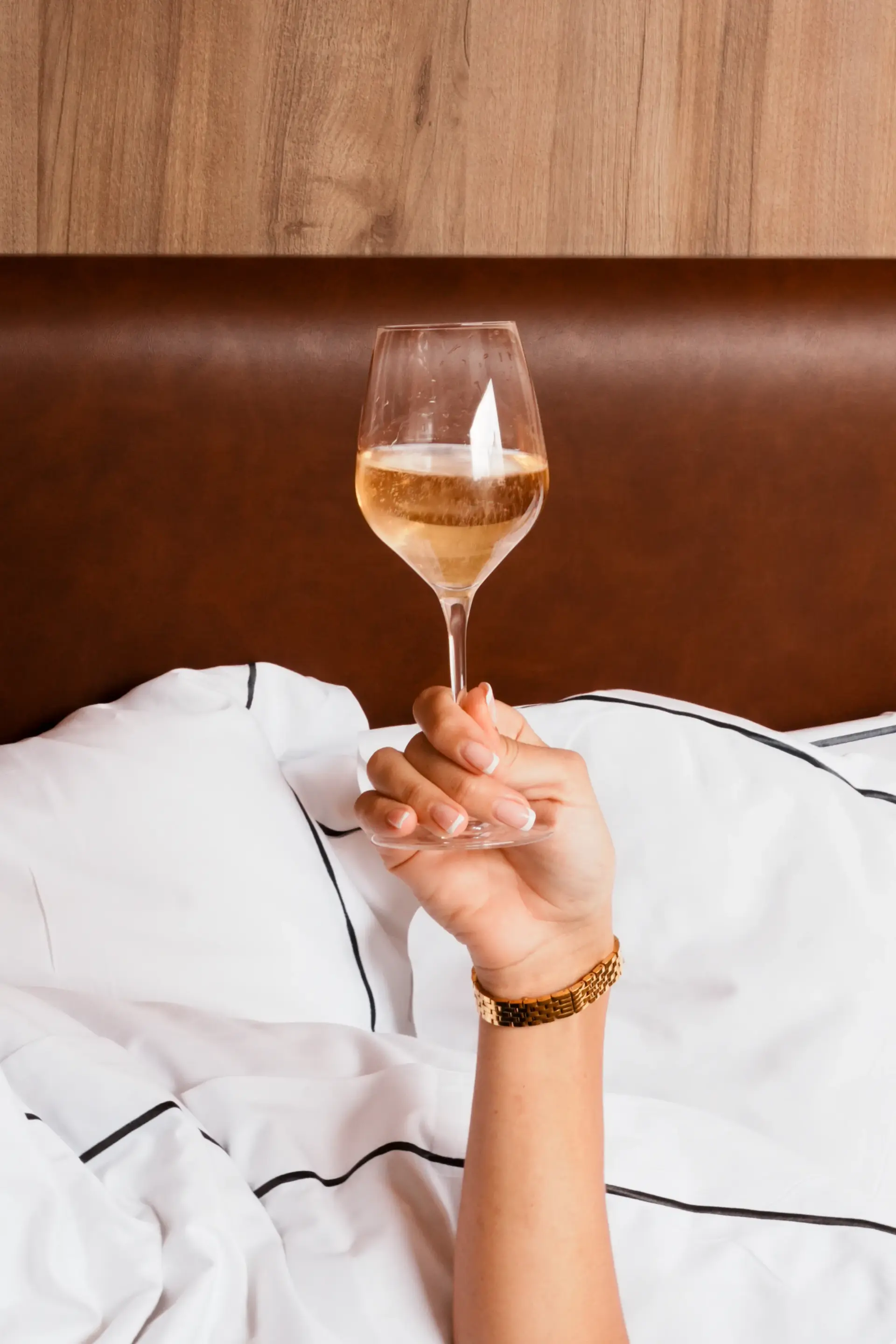 Verre de champagne tenu dans un lit